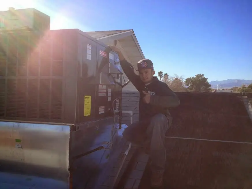 HVAC technician performing Air Duct Cleaning on a rooftop unit in Bronxville